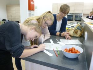 Theorie und Praxis beim Klimafrühstück: Kathrin Stockmayer von der Verbraucherzentrale mit Schülerinnen bei der Dokumentation.
